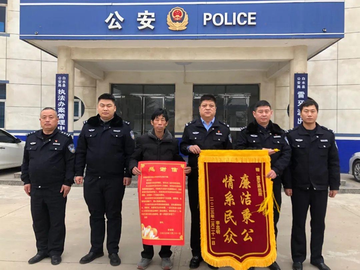 群眾李先生將一面印有“情系民眾 廉潔秉公”的錦旗送到白水縣公安局雷牙派出所。
