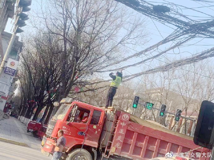 電纜掉落致交通受阻，潼關(guān)交警秒變“托舉哥”保暢通。