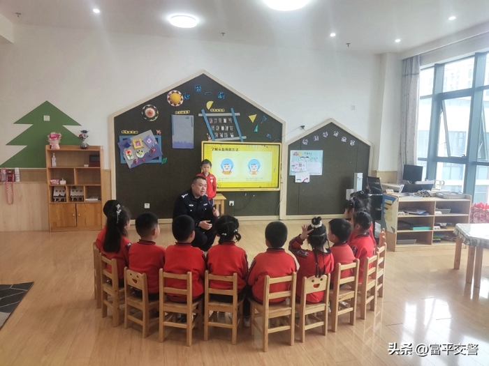 幼兒園小朋友圍坐一圈，聚精會(huì)神地聽(tīng)著富平交警的講解。