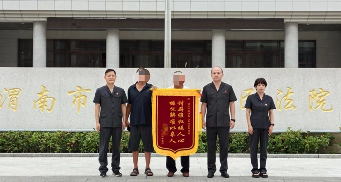 案件當(dāng)事人趙某走進(jìn)渭南市臨渭區(qū)人民法院將一面錦旗送至法官手中。